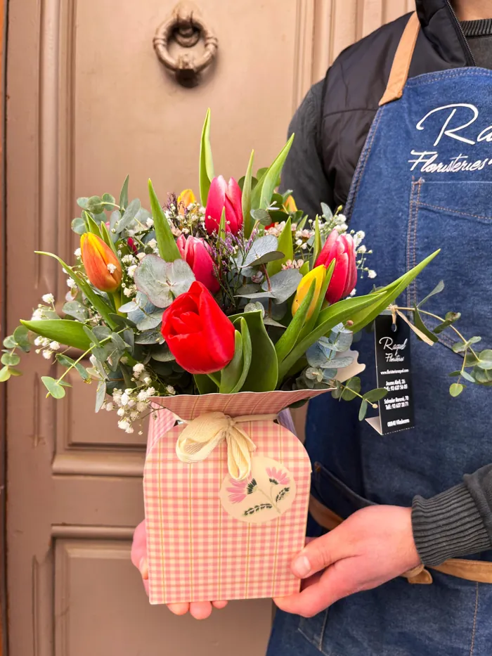 Ramo de tulipanes y flores de temporada en bolsa de regalo