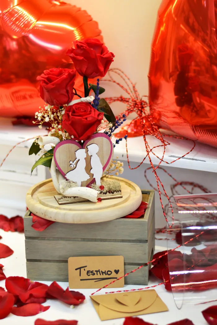 Detalle de San Valentín con rosas rojas y pareja de madera